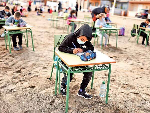 Niños toman clases a la orilla del mar en España