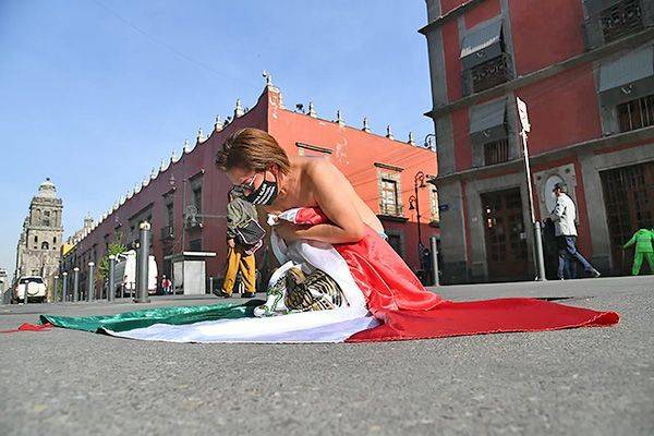 Mujer envuelta en bandera frente a Palacio Nacional exige justicia