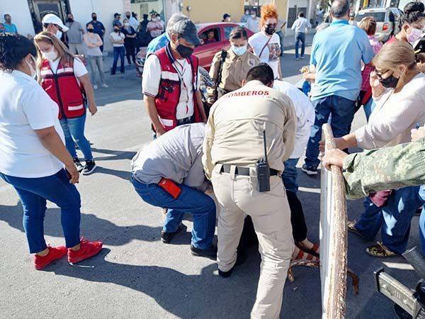 Cae mujer en fila de vacuna