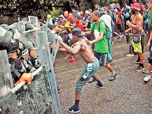 Migrantes rompen muro de GN; salieron en caravana desde Tapachula, Chiapas
