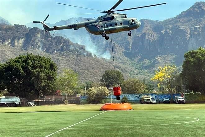 Combaten por aire incendio forestal en Tepoztlán