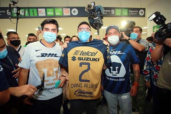 Planta Dani Alves a aficionados de Pumas en el AICM