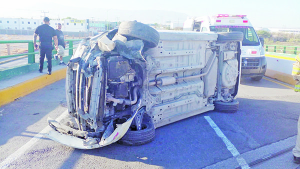 Voltea su carro arriba de puente