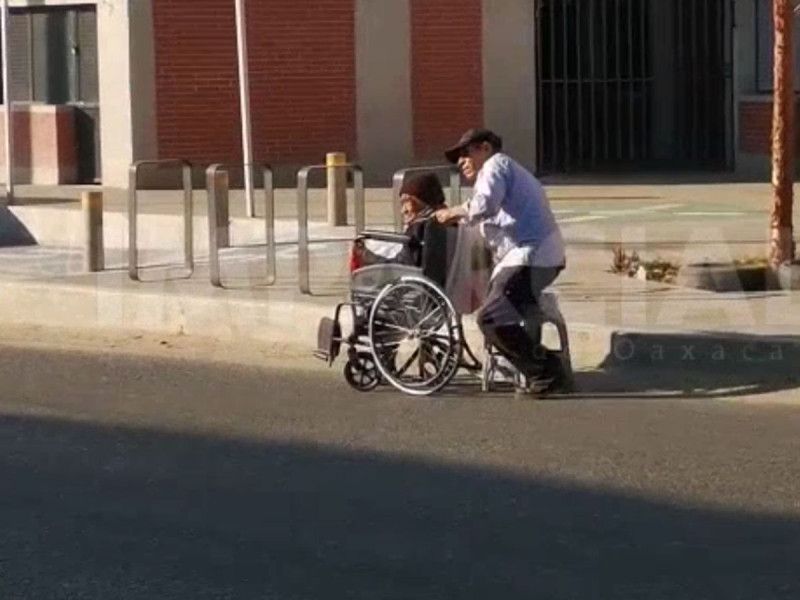 Adulto mayor sin una pierna empuja la silla de ruedas de su esposa; los buscan