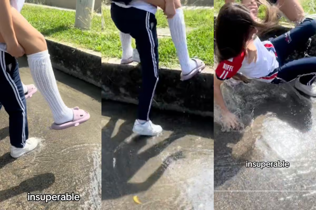 Dos jóvenes intentan cruzar la calle sin mojarse y acaban cayendo en el agua de la alcantarilla