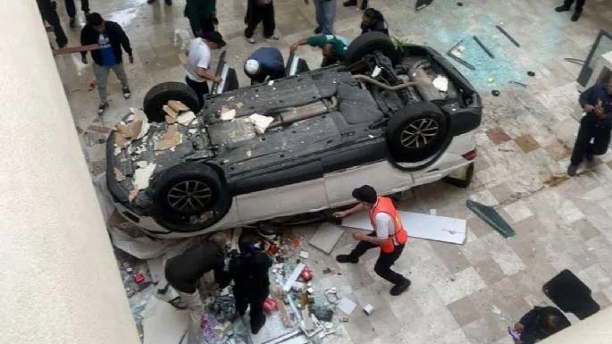 Cae vehículo tres niveles al interior del centro comercial